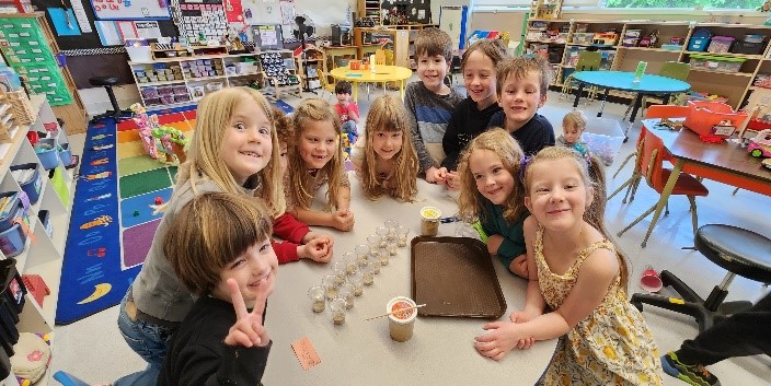 A group of children sitting around a table
Description automatically generated