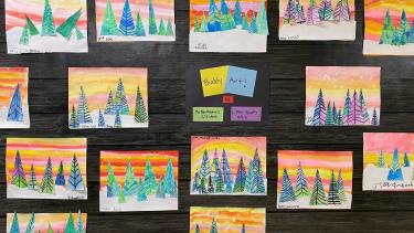 Forest trees against orange water colour skies